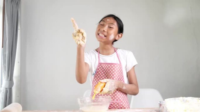 亚洲女孩在家自己做面包或比萨饼面团，生活方式概念。