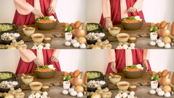 特写亚洲女性穿着韩服传统服装烹饪泡菜韩国食物，桌上有蔬菜