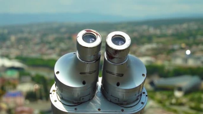 全景，在阳光明媚的日子在城市和山脉的背景上观看双筒望远镜。格鲁吉亚第比利斯。