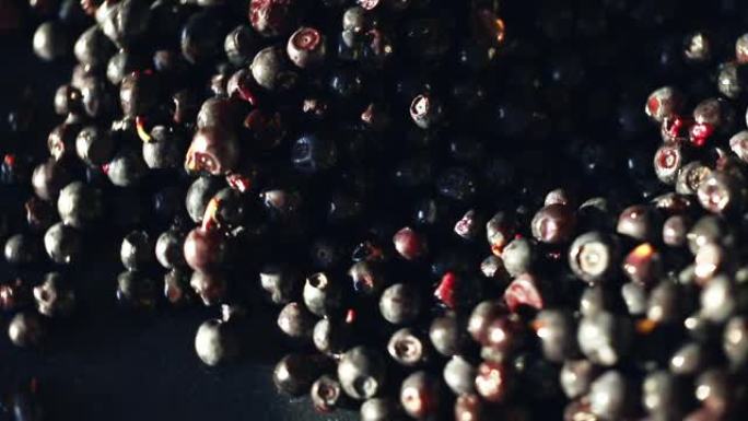 一堆蓝莓浆果的特写镜头，它们在阳光下在盘子上旋转。
