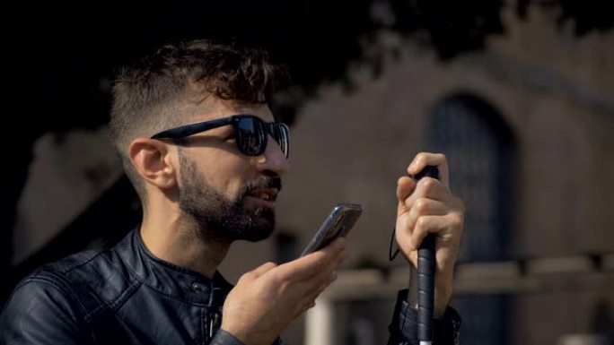 盲人年轻人在城市的智能手机上录制人声信息