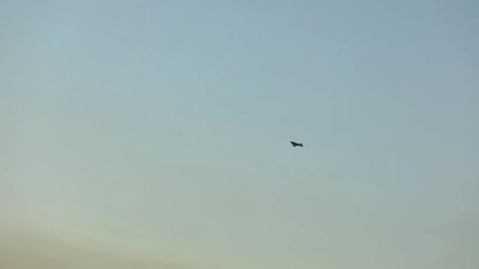 空中无人机在美丽的云彩背景下。彩色天空背景上的军用无人机
