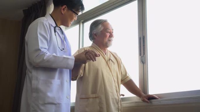 年轻的亚洲医生帮助老人病人在医院行走