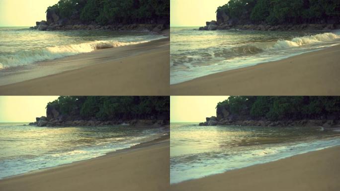 4k视频画面，海浪冲刷了热带海滩海水破裂的沙质顶部的脚印。