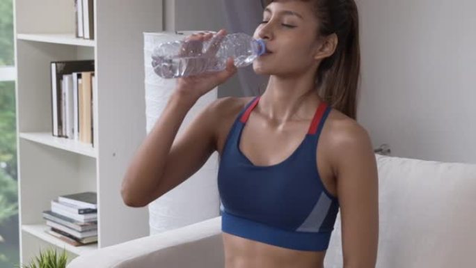 健身女子独自在家极端运动后坐着喝水，健康健身
