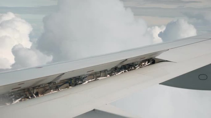 空中云层中的飞机机翼。飞机机翼的机构和细节的特写视图