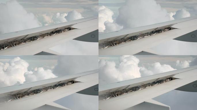 空中云层中的飞机机翼。飞机机翼的机构和细节的特写视图