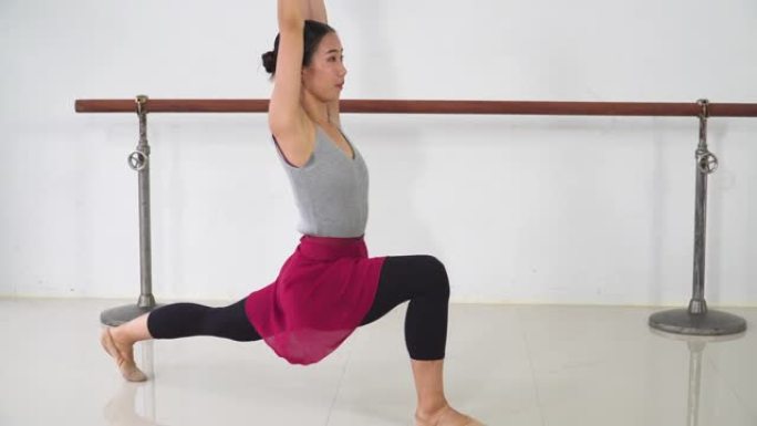 手持视图: 年轻的芭蕾舞女坐着时伸展腿