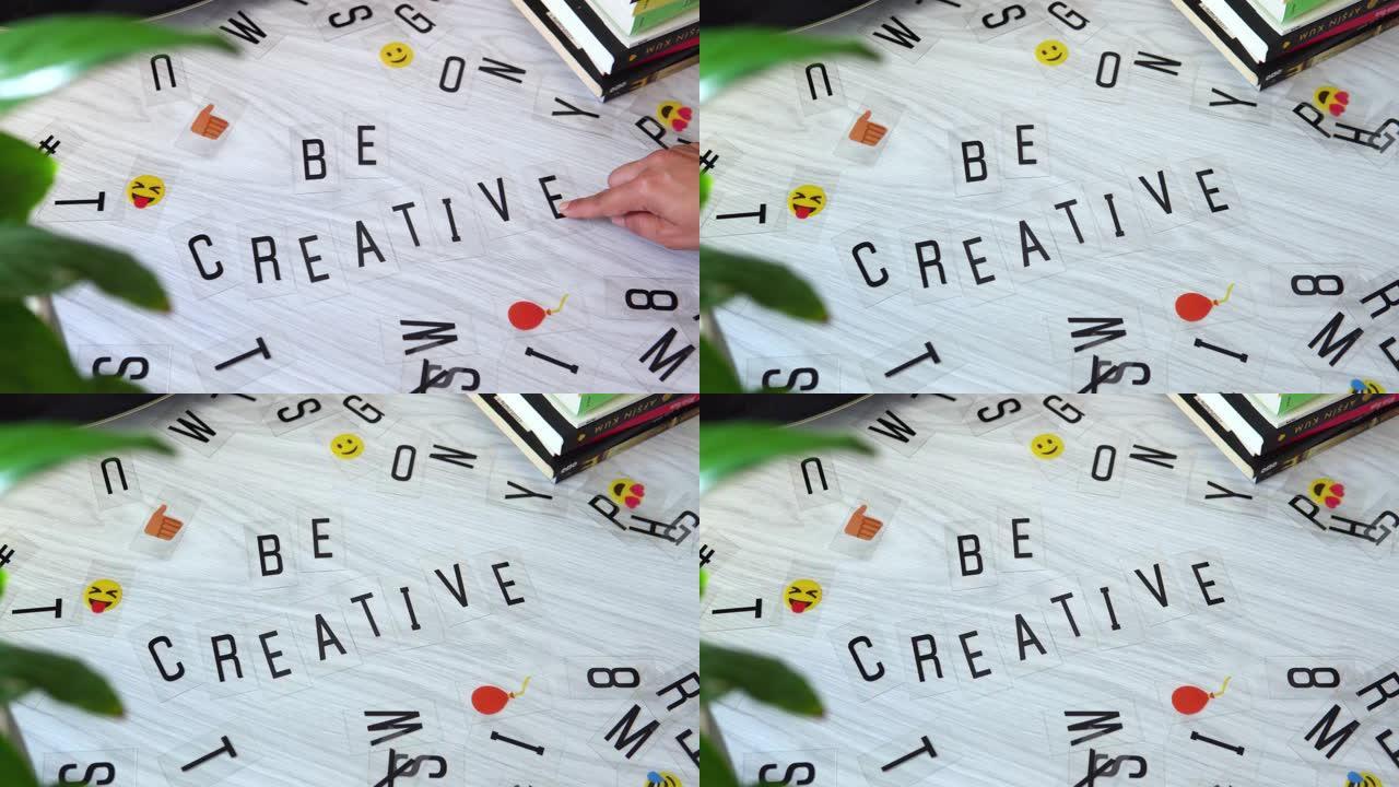 女性手将字母放在一起并写下 “具有创造力” 一词