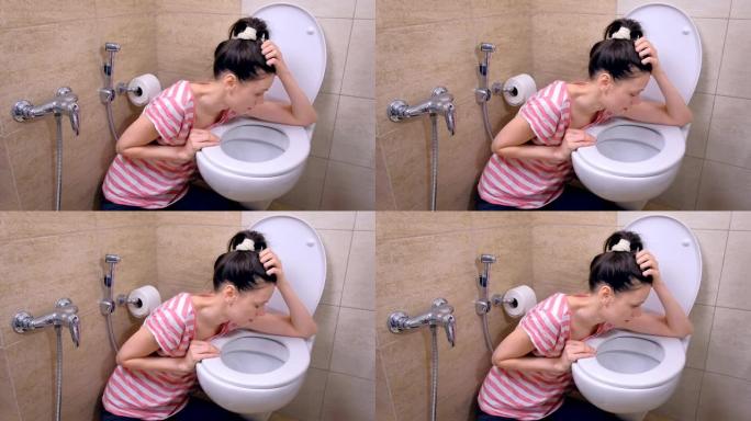 喝醉的女人在厕所里呕吐，坐在家里的地板上，宿醉，侧视图。