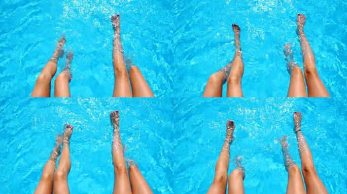 年轻妇女坐在游泳池边，在水中晃来晃去。两个女孩，双腿晒黑，在盆子附近放松。女士们在度假胜地享受假期。