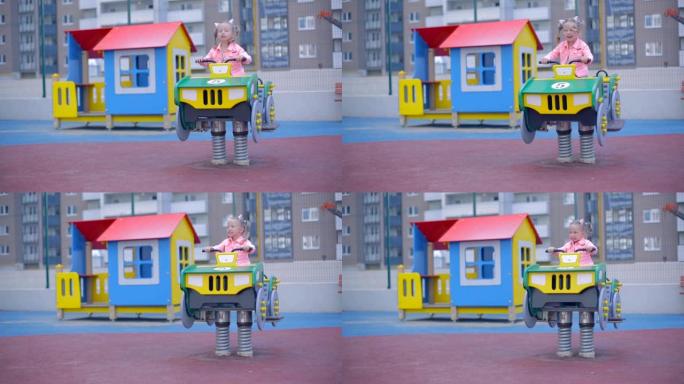 穿着牛仔裤的金发小女孩在儿童公园玩耍。