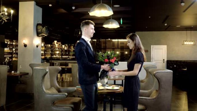 浪漫的约会。男人和女人在一家现代餐厅见面共进晚餐。4K