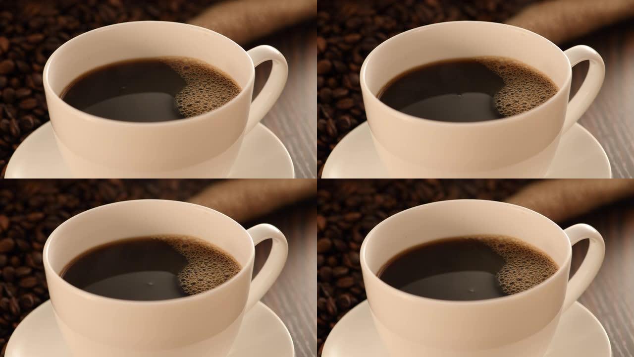 在烘焙咖啡豆背景下的杯子里的咖啡