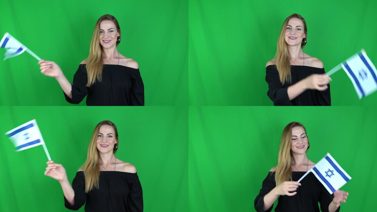 年轻的金发女子挥舞着以色列国旗在希腊国旗绿色屏幕前，色度关键背景-以色列国旗股票视频剪辑片段