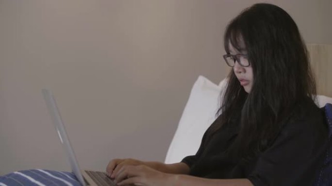 年轻女子在家工作，在电脑上打字。