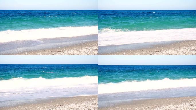 在碧蓝的海水中，两个人游泳。夏天炎热的晴天。海上，海滩上的柔软波浪。带有白色泡沫的波浪被冲上岸