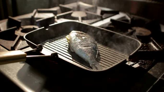 在炉子上的蒸汽云中的平底锅上的特写鱼