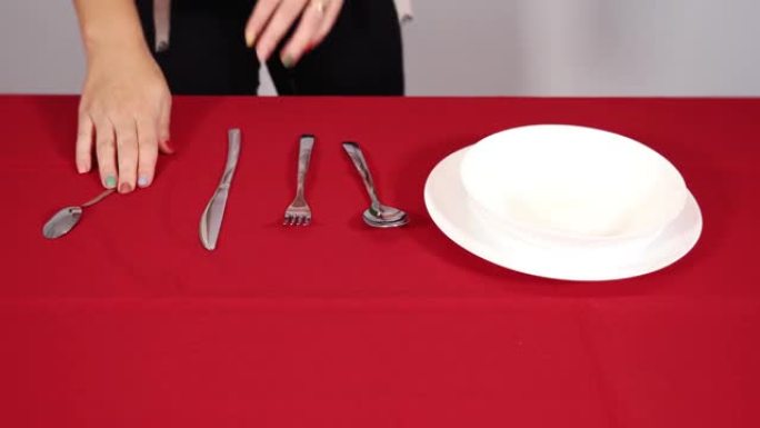 人的手把银勺叉子和刀子扔在桌子上
