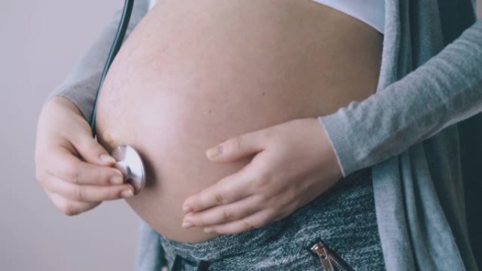 孕妇用听诊器特写镜头触摸婴儿肿块