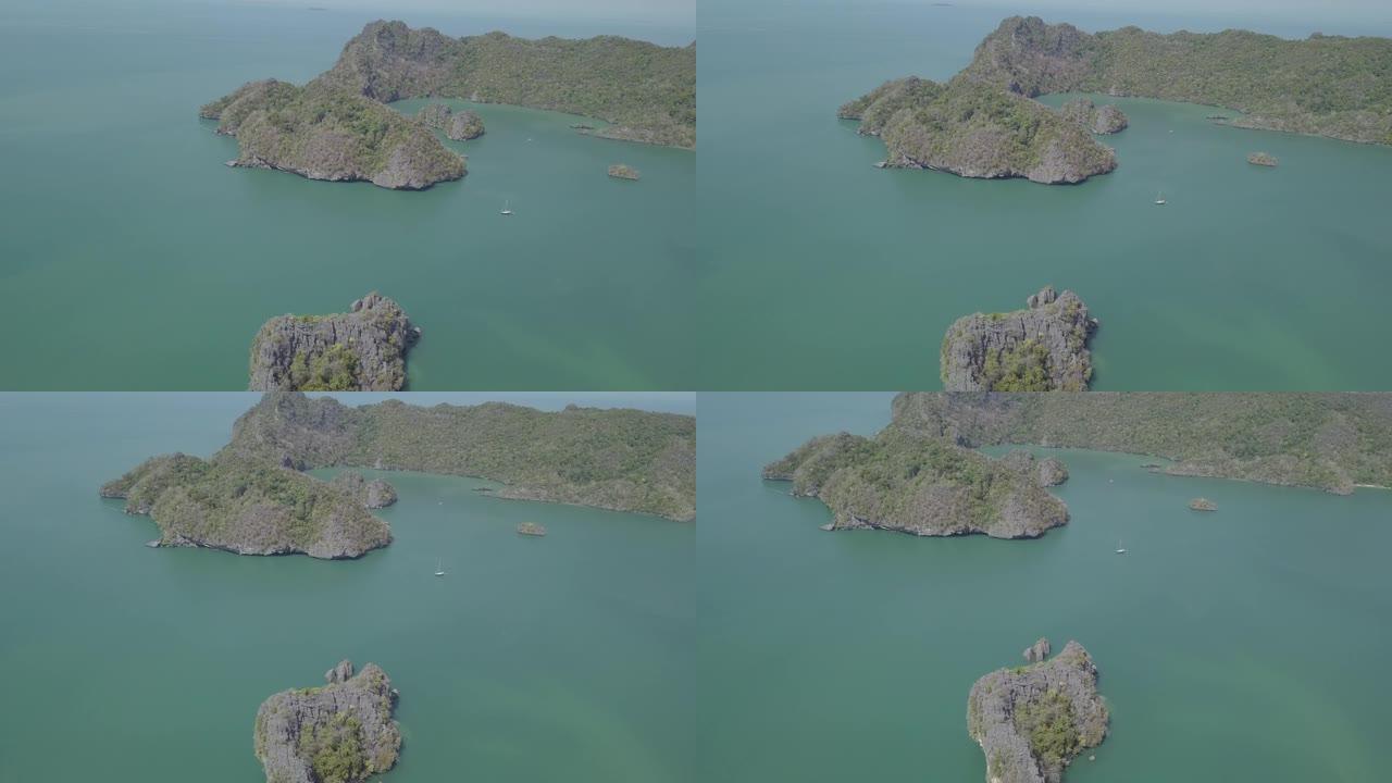 海中岛屿的航拍画面。船漂浮在岛附近。Park Kilim Geforest，兰卡威，马来西亚。无人机