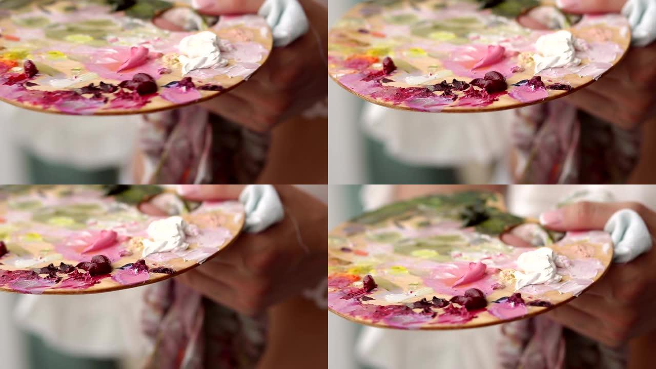 一个女孩的特写镜头，手里拿着油画颜料。慢动作。