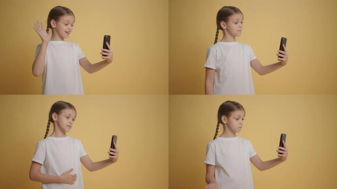 女孩在黄色背景下使用智能手机在视频聊天中聊天慢动作