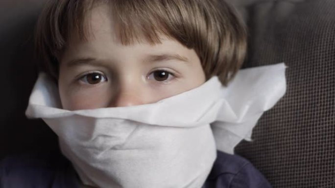 不健康生病的男孩的肖像用餐巾纸关闭她的鼻子过敏或鼻炎。不幸的孩子患有流鼻涕，打喷嚏和鼻涕。儿童感冒流