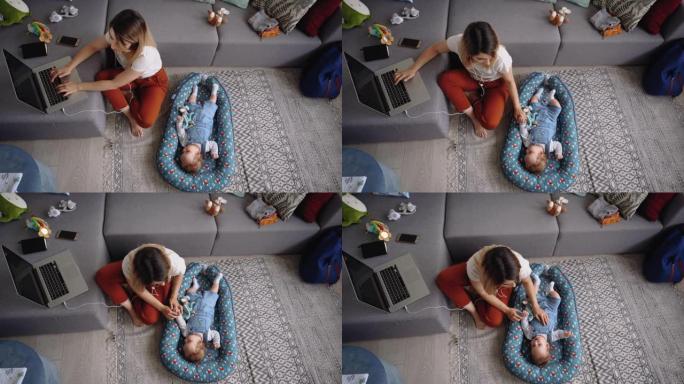 年轻的单身母亲在工作休息时与男婴玩耍