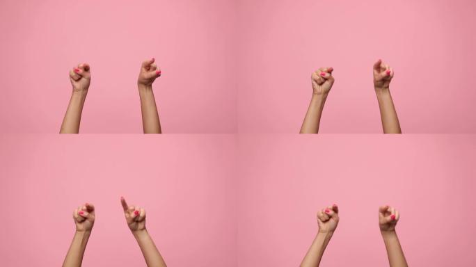女人在空中牵着手，指着手指，在粉红色的背景上跳舞