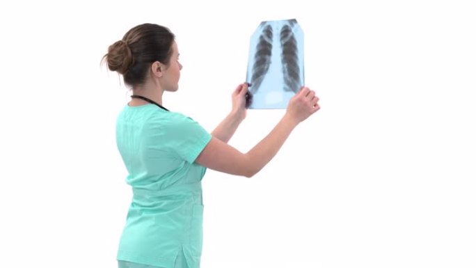 专业女性医生检查肺部x光。专家持有胸部的透明图像并对其进行研究。医学诊断概念