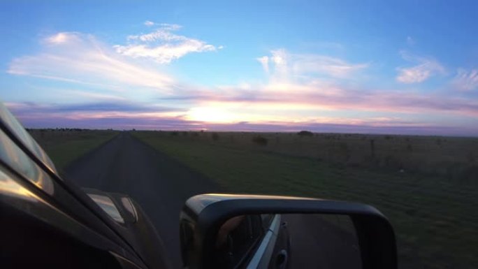 POV视角的司机在澳大利亚的道路，从车窗看，美丽的云在五颜六色的天空。