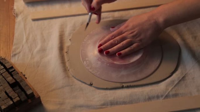 在车间制作粘土板的过程。手工陶瓷制作的装饰餐具特写。