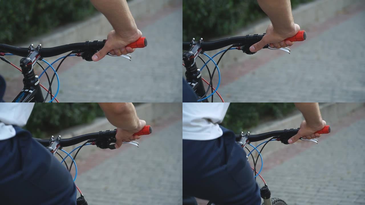 骑自行车的人拿着车把和驾驶自行车的手。无法识别的男性骑自行车的人骑自行车换档。运动男在户外骑自行车。