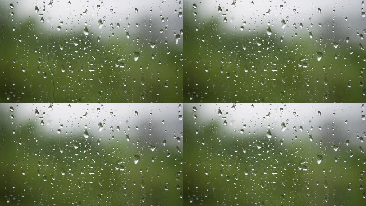 强烈的雨水冲向窗户玻璃并流下来。特写。雨季玻璃背景上的雨滴