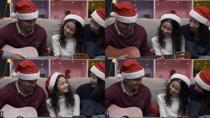 女儿小女孩和父亲在圣诞节那天微笑着弹吉他和唱歌
