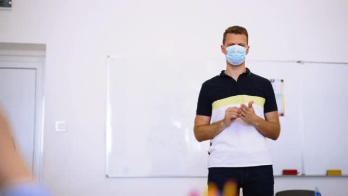 带口罩的老师激励孩子在冠状病毒后活跃在教室里