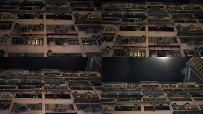 夜景下香港人满为患的旧公寓大楼的低角度。当地居住区