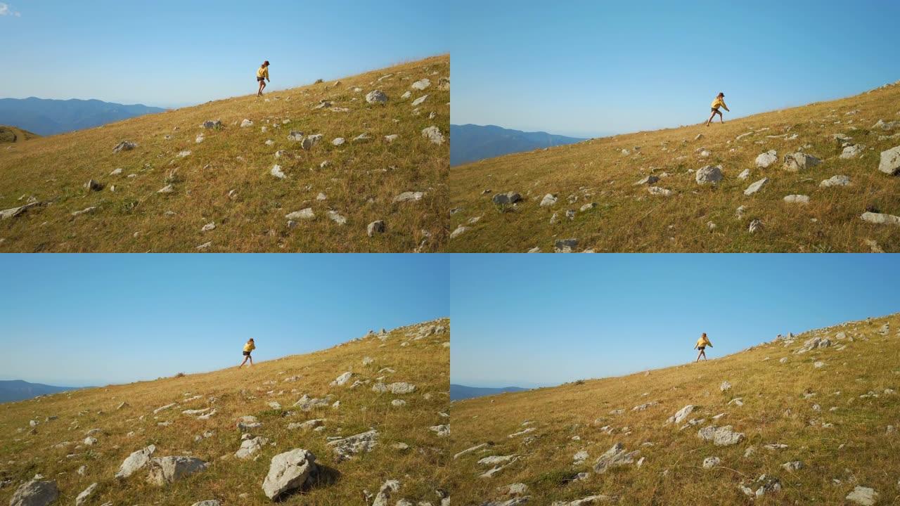 穿着短裤的女人在蓝天背景上爬山