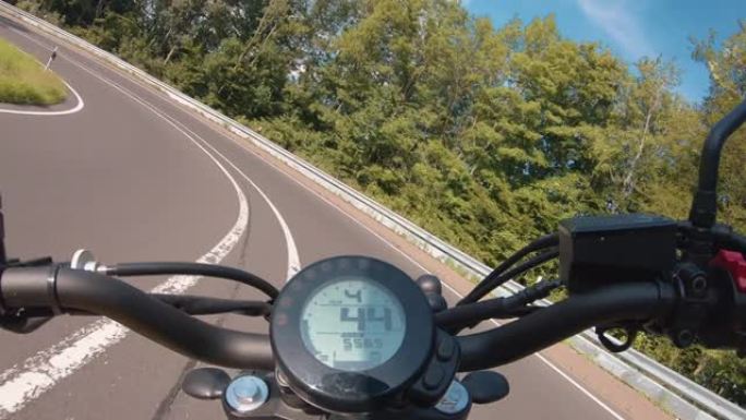 现代扰频器摩托车在林道骑行。在摩托车之旅中驾驶空旷的道路玩得开心。