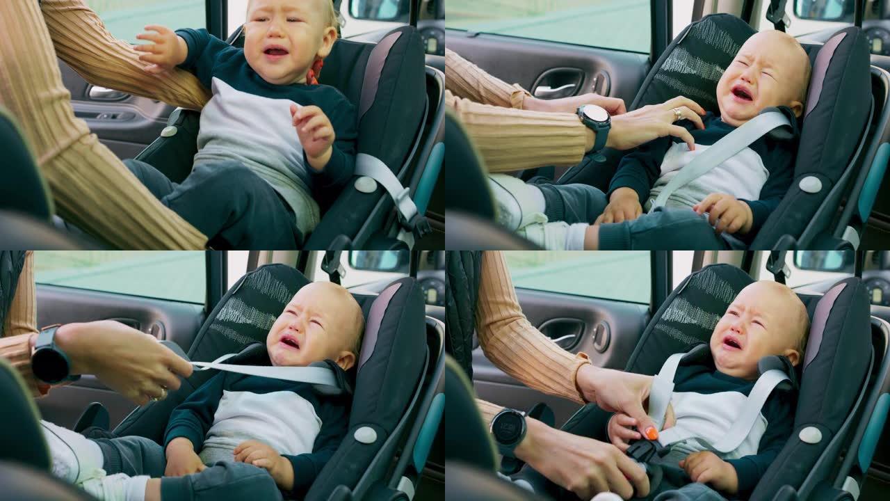 车内摄像头。特写婴儿汽车座椅。男婴出现在他母亲的手上，母亲将婴儿放在婴儿汽车座椅内。婴儿在哭，母亲系
