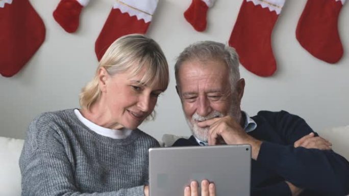 老年高加索老人男女一起使用平板电脑并在线玩互联网