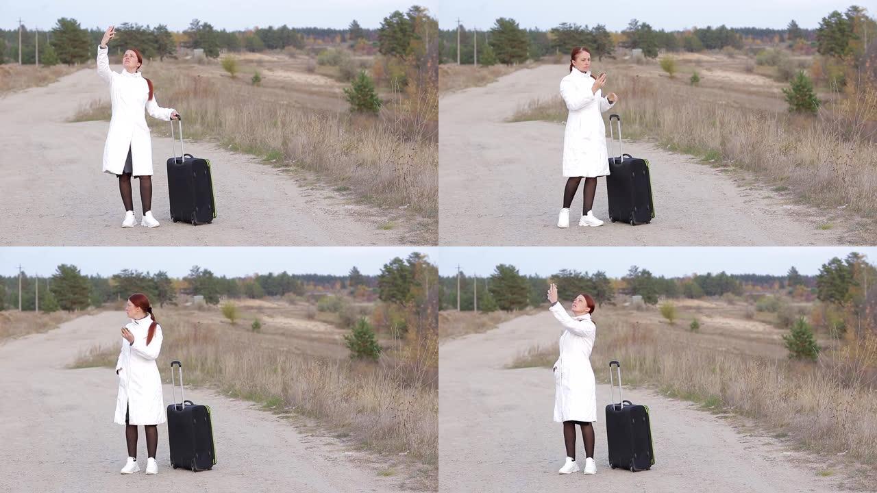 一个带着手提箱的孤独女人在没有蜂窝连接的空旷道路上行走，试图捕捉电话信号。