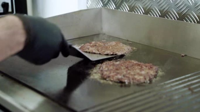 煮牛肉和猪排作为汉堡。厨师从锅中取出油炸肉丸