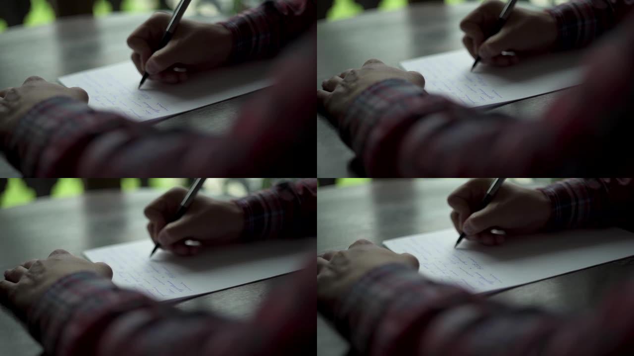 Kuchl/奥地利-2019年8月22日: 男人的手在木桌上的白纸上写信。复古信，婚礼爱情故事，新郎