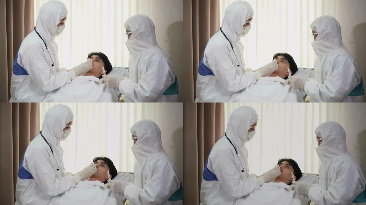 一组穿着ppe套装的亚洲医生目前正在医院检疫病房检查感染并治疗冠状病毒或covid 19咳嗽的患者。
