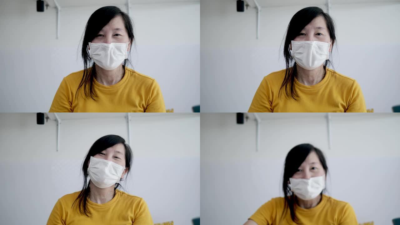 在家工作时戴着面具微笑的亚洲女人的概念。