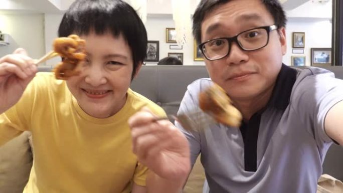 亚洲朋友在reataurant进行视频通话和进餐