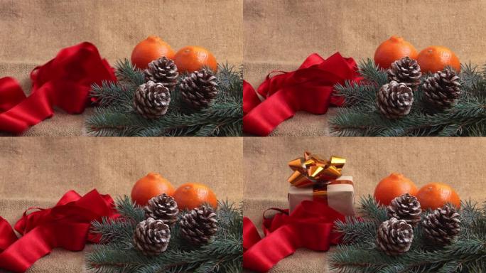新年的组成，橘子，松果和新年树的树枝被解雇。红丝带和礼物落在框架中的桌子上。