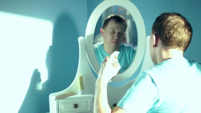 年轻人坐在镜子前，在自己身上喷香水